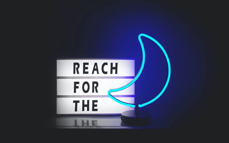 reach for the and blue moon neon signages